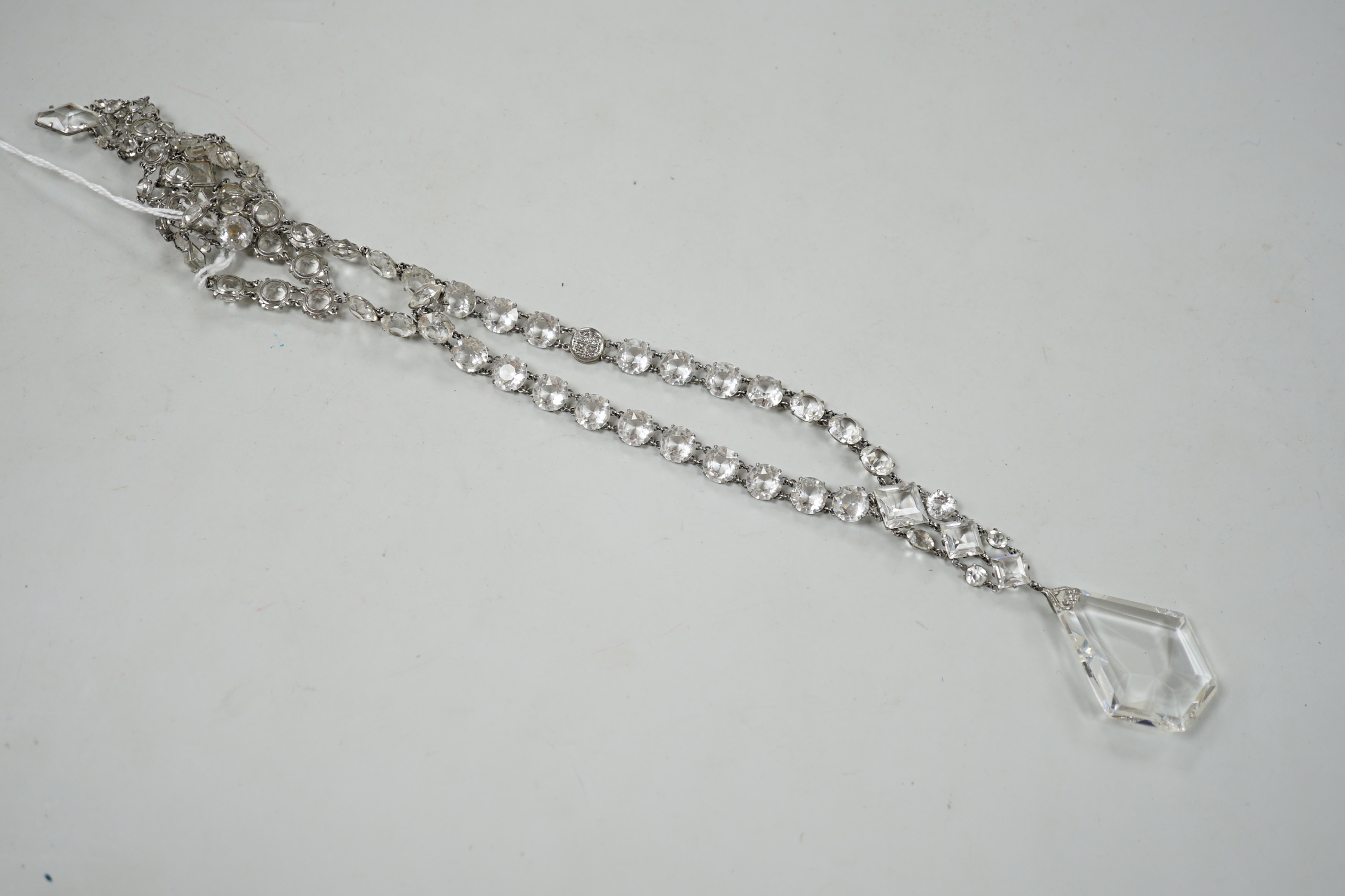 An early 20th century ornate white metal and facet cut paste set drop necklace, overall approx. 44cm.